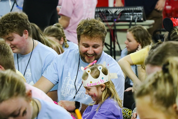 A crowd of college students and children at a charity event for Children's Miracle Network.