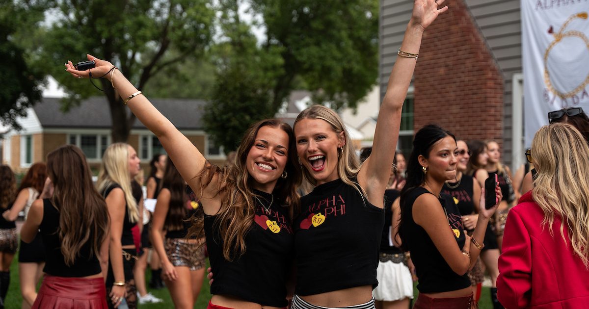 Two members of Alpha Phi outside of their sorority house.