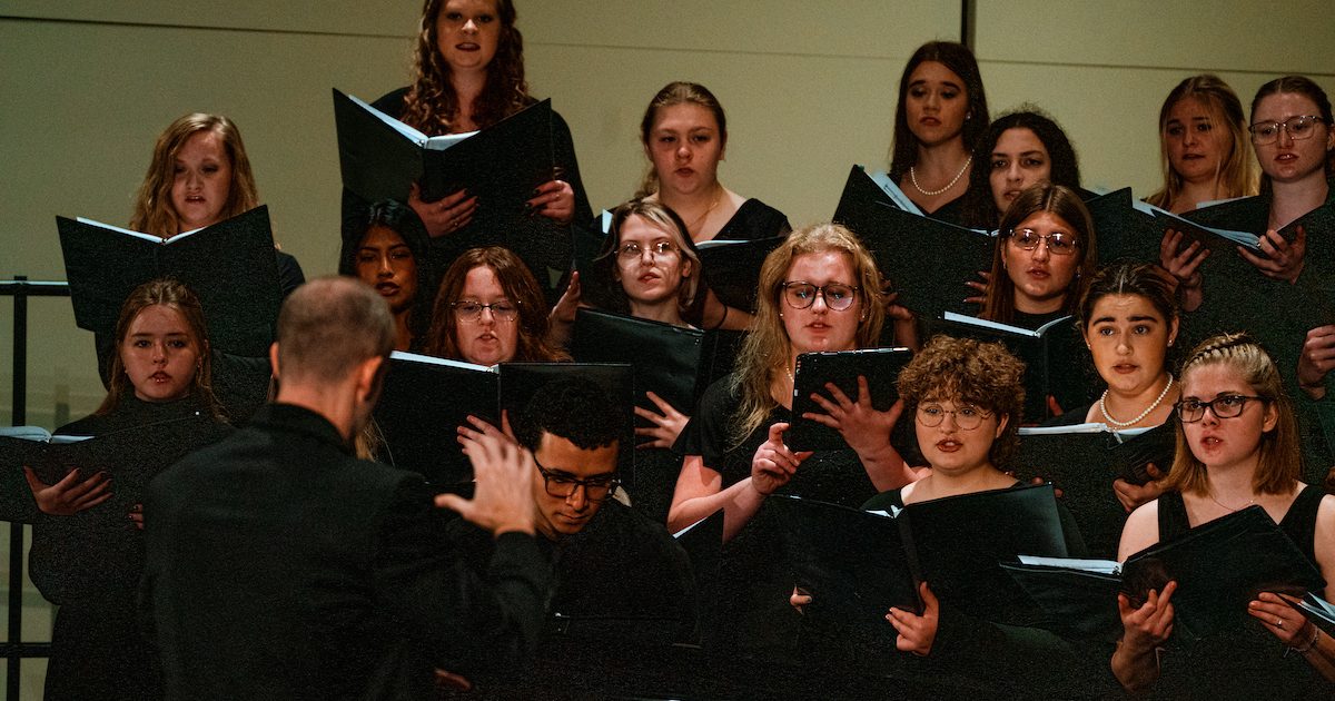 The USD Choir singing wearing all black.
