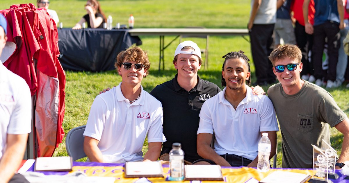Four group members of Delta Tau Delta sitting outside.