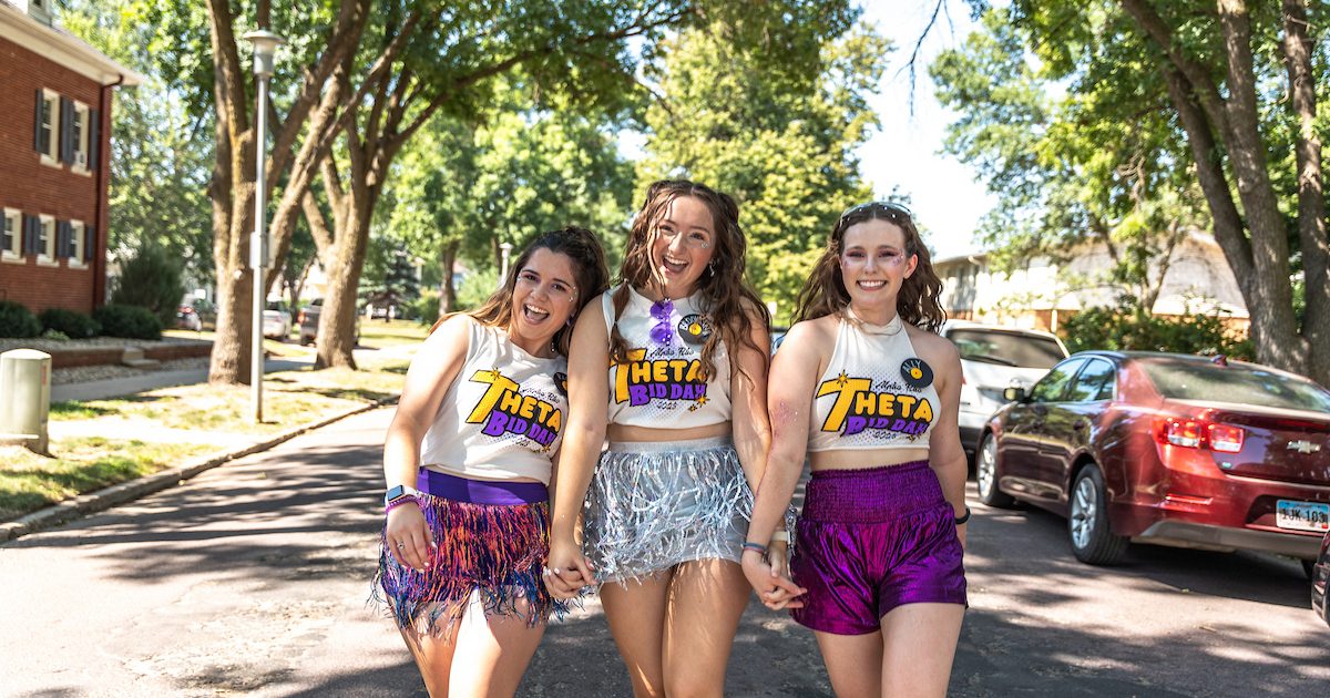Three Theta members walking down the street.