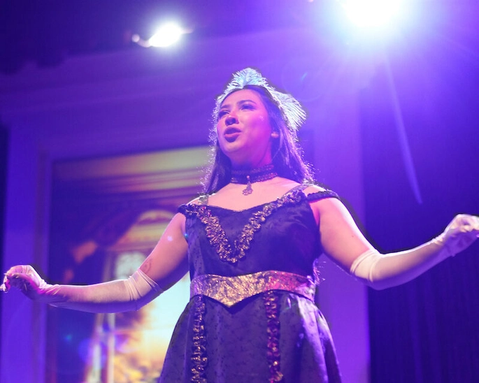 Young woman in a formal dress singing opera.