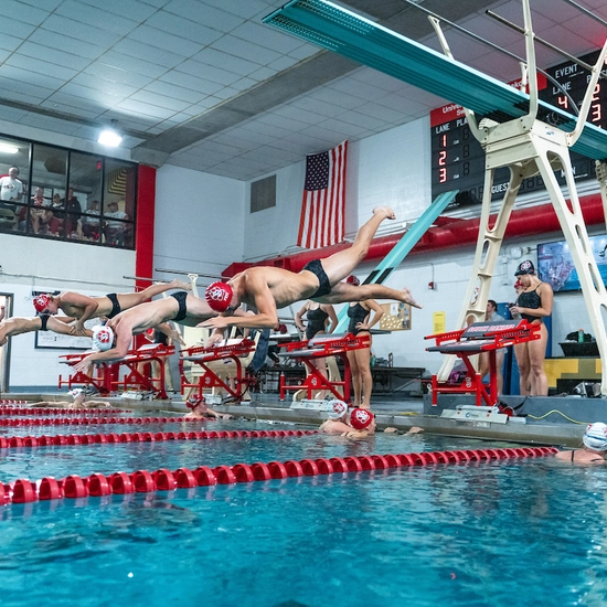 Swimmers diving into the water