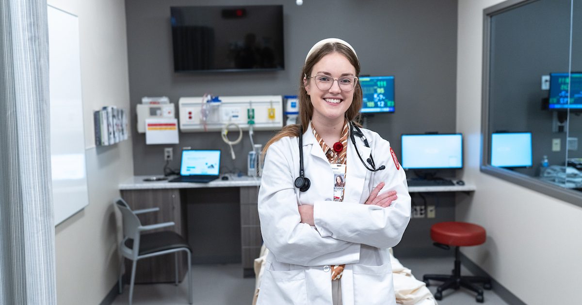 Medical student wearing white coat in a doctors office.