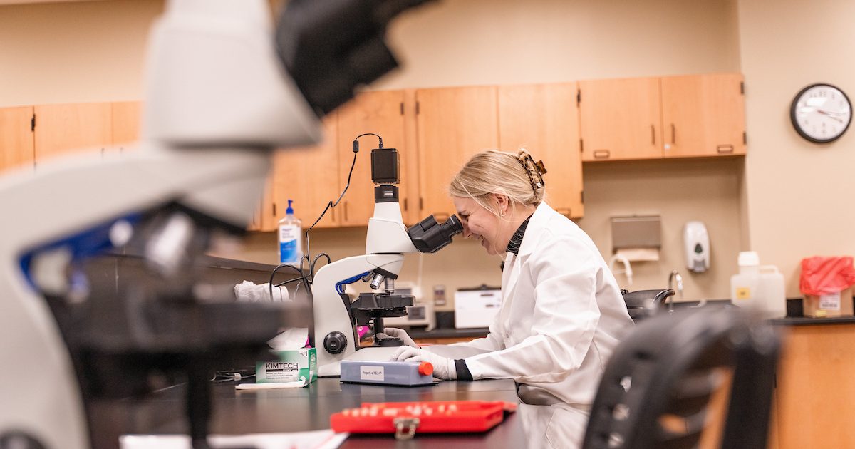 A med student analyzing something in a lab.