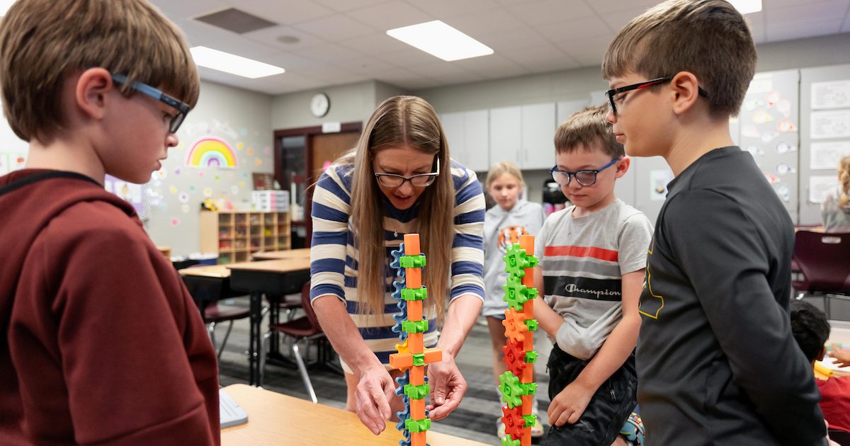 USD student teacher with children building blocks.