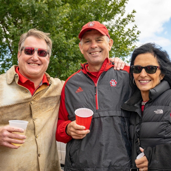 Dakota Days throwback of alum posing at tailgate
