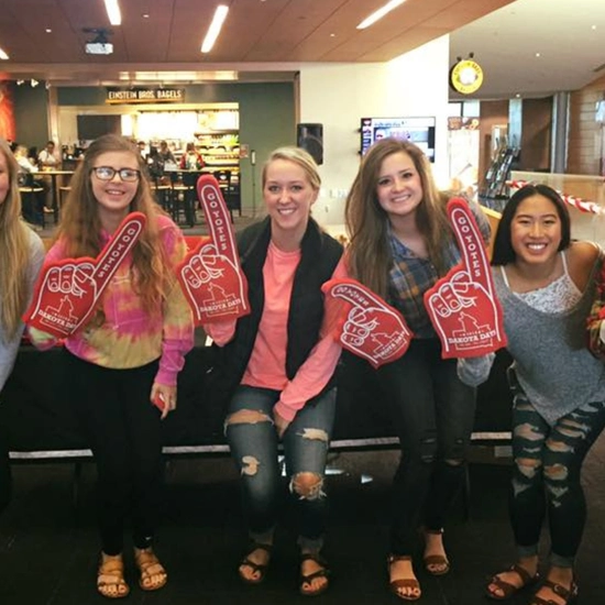 Dakota Days throwback of a group of girls posing with foam fingers