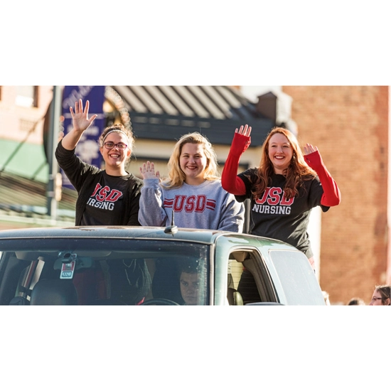Dakota Days throwback of students riding in a car at the parade