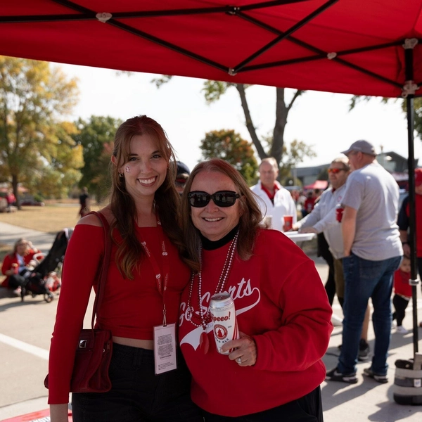 Alumni pose for a picture at a tailgate