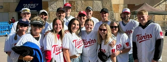 Group photo of alumni in Twins jerseys outside Target Field