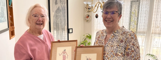 Sandra Percy and Carol Geu holding donated Oscar Howe paintings.