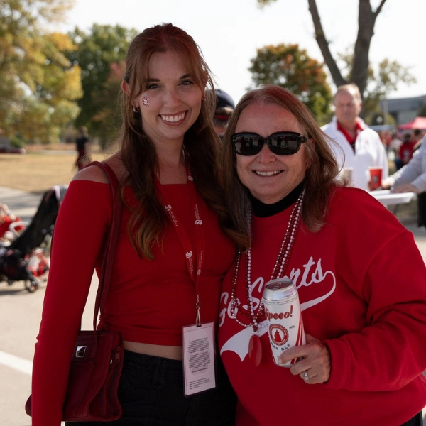 Calli Connors and Michelle Van Maanen pose at a tailgate